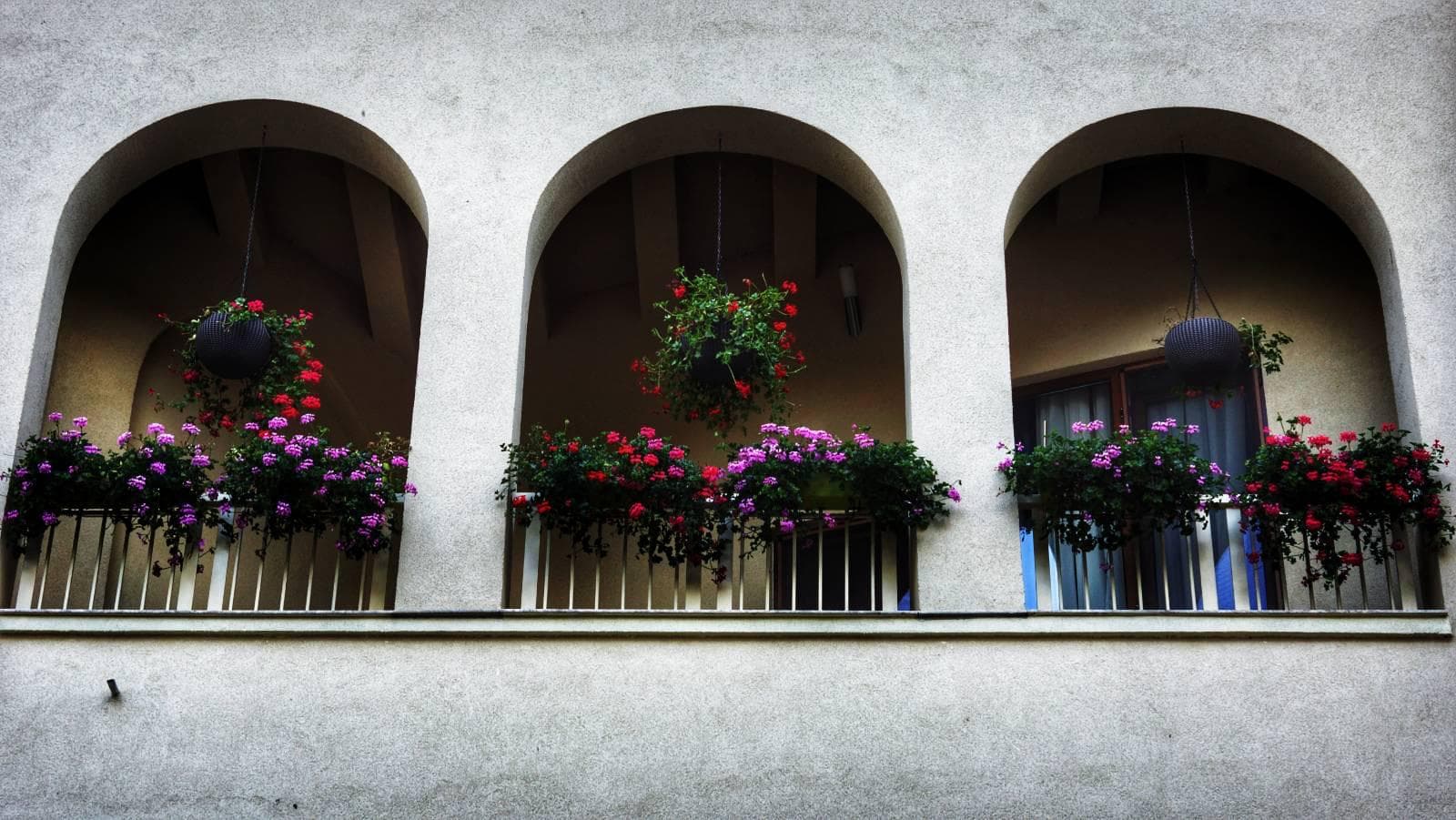 Arcadele etajului superior cu mușcate colorate